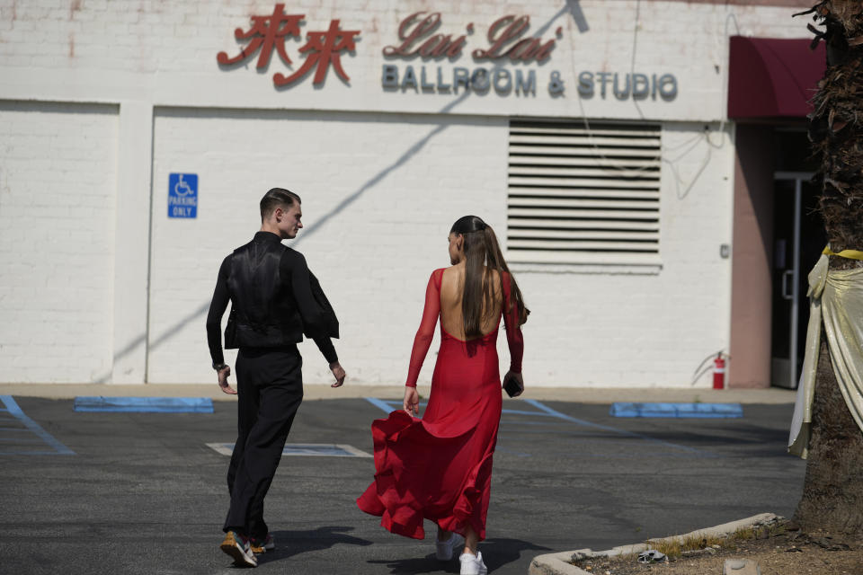 Vlad Ogurstov, left, and Kristi Semochko, professional teachers and dancers, walk back into the Lai Lai Ballroom & Studio in Alhambra, Calif., on Saturday, May 20, 2023. A Community Dance celebration hosted by Brandon Tsay, who disarmed a mass shooter during Lunar New Year celebrations at his family's dance studio, is part of events honoring Asian American Pacific Islander (AAPI) Heritage Month. (AP Photo/Damian Dovarganes)