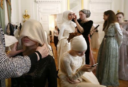 Models get assistance while preparing backstage before a show of the Firdaws fashion house led by Aishat Kadyrova, daughter of the Chechen Republic head Ramzan Kadyrov, at the Mercedes-Benz Fashion Week Russia in Moscow, Russia, March 17, 2017. REUTERS/Sergei Karpukhin