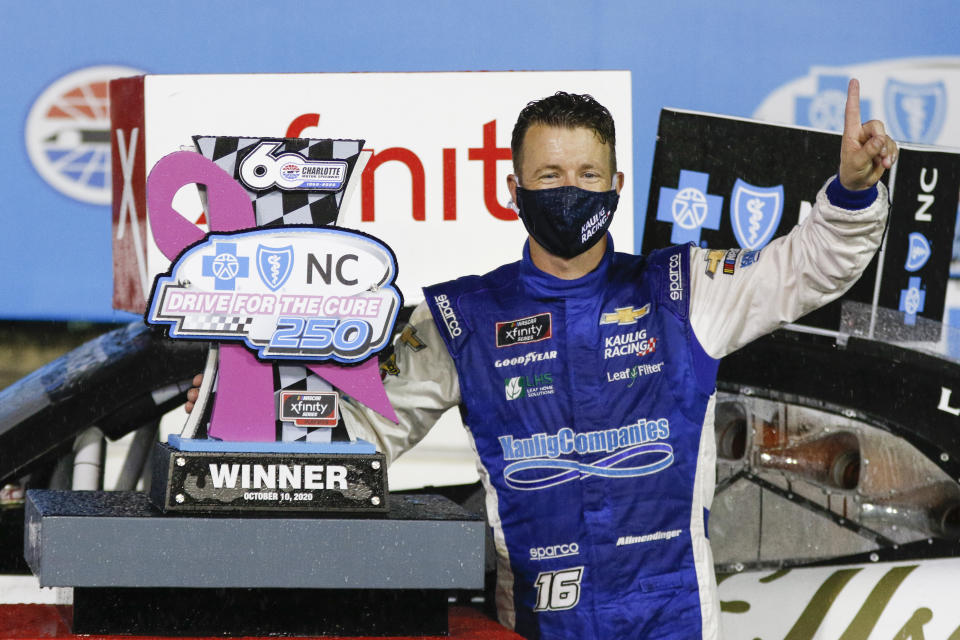 AJ Allmendinger stands beside his trophy after winning a NASCAR Xfinity Series auto race at Charlotte Motor Speedway in Concord, N.C., Saturday, Oct. 10, 2020. (AP Photo/Nell Redmond)