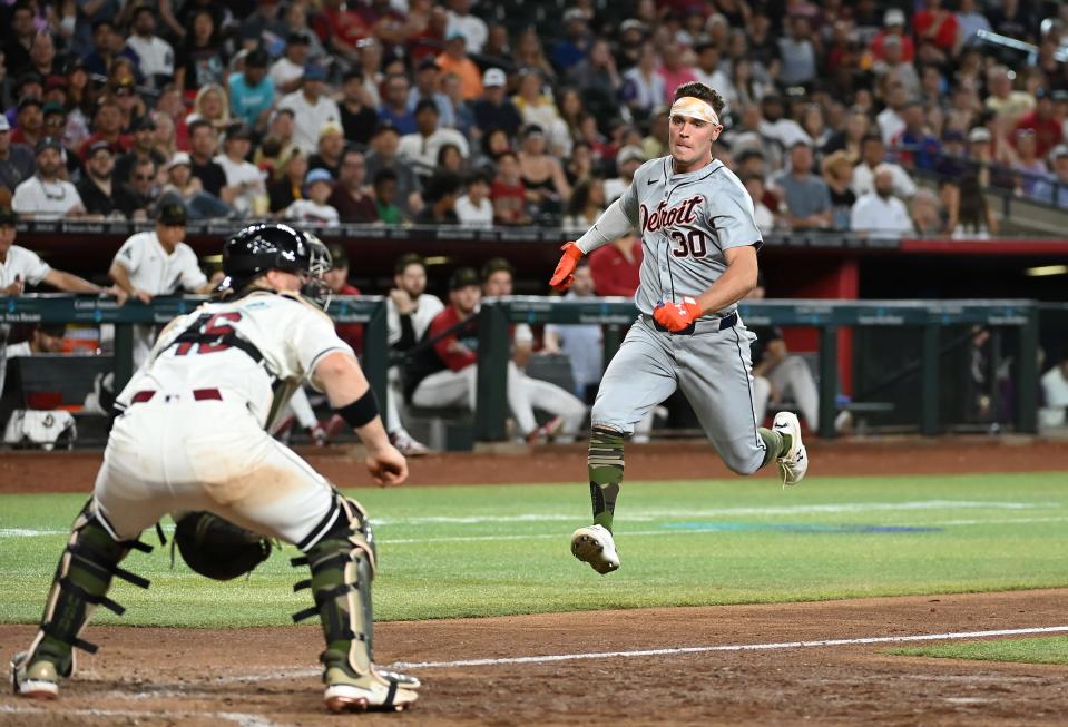Kerry Carpenter of the Detroit Tigers attempts to score as Tucker Barnhart of the Arizona Diamondbacks waits for the throw during the seventh inning at Chase Field in Phoenix on Sunday, May 19, 2024.