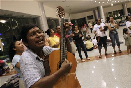 A man plays the guitar for people camping out at a shelter in Acapulco September 20, 2013. REUTERS/Henry Romero