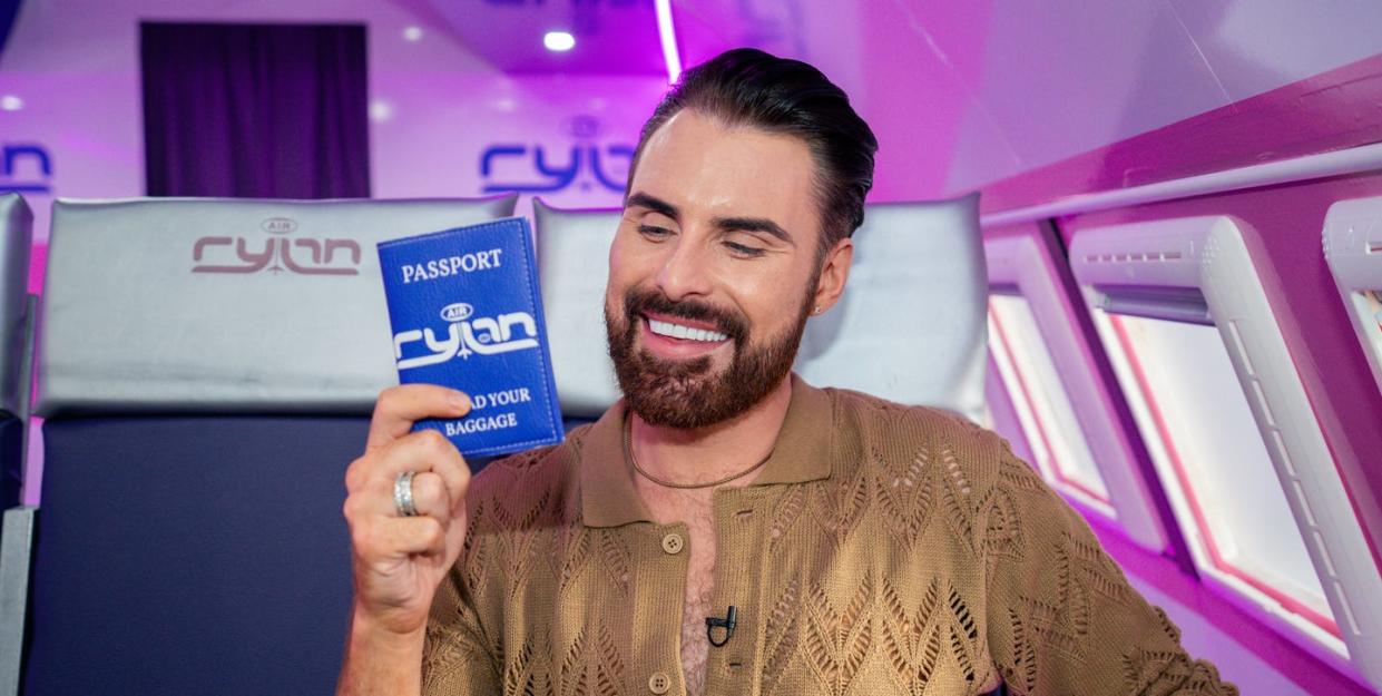 rylan clark holds up a blue passport sized wallet for air rylan