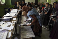 Afghan election workers counts ballots during the parliamentary elections, at a polling station in Kabul, Afghanistan, Sunday, Oct. 21, 2018. The elections entered a second day after delays caused by violence and technical issues, as a roadside bomb killed nearly a dozen civilians on Sunday, including several children. (AP Photo/Rahmat Gul)