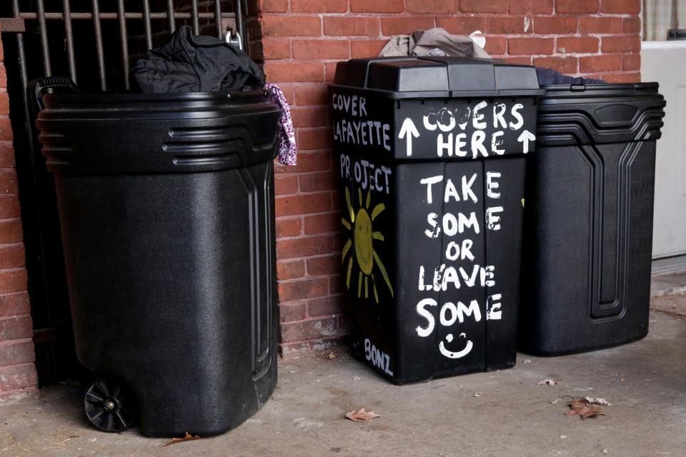 Bins filled with cold weather apparel sit on a Main Street porch for those who are in need, Tuesday, Dec. 1, 2020 in Lafayette.