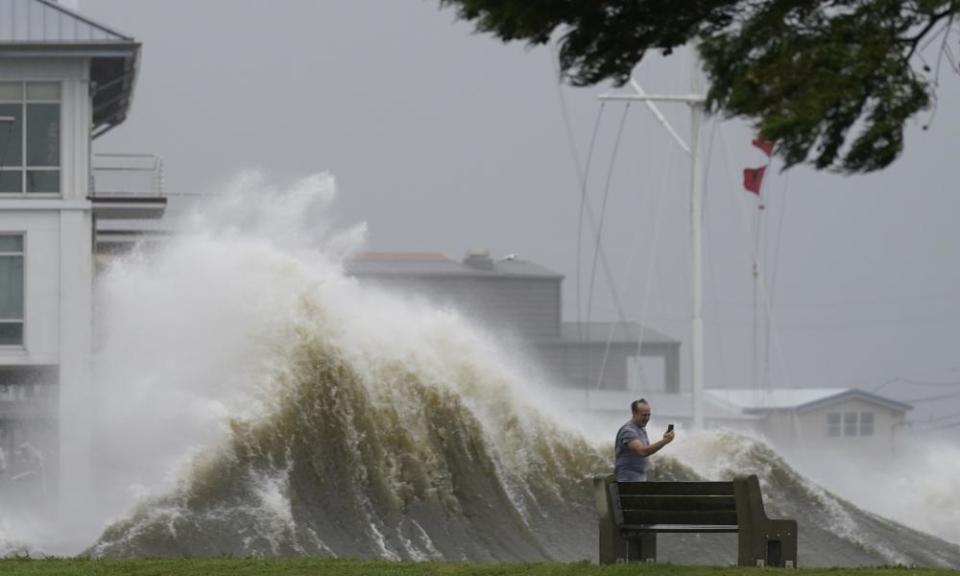 A man takes pictures of high waves along the shore of Lake Pontchartrain, in New Orleans.