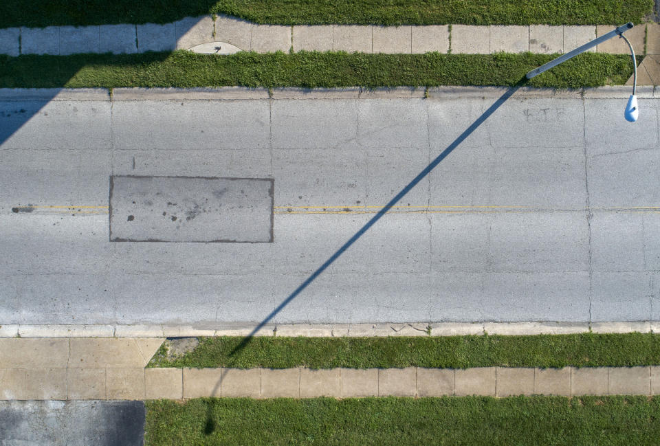 This July 27, 2019, photo shows where Michael Brown was killed, marked by the rectangular box in the middle of Canfield Drive, in Ferguson, Mo. Brown was shot and killed Aug. 9, 2014, by Ferguson police officer Darren Willson. His body lay in the street for hours as police investigated. At the family’s request, that section of asphalt was removed and repaved, leaving the scarred street. (AP Photo/Jeff Roberson)