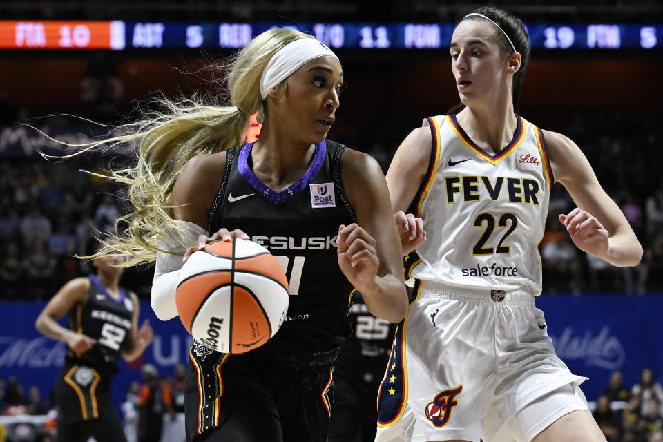 Connecticut Sun guard DiJonai Carrington (21) drives agasint Indiana Fever guard Caitlin Clark (22) during the second quarter of a WNBA basketball game, Tuesday, May 14, 2024, in Uncasville, Conn. (AP Photo/Jessica Hill)