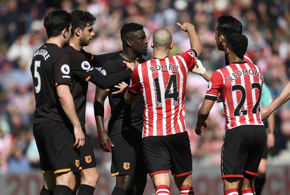 <p>Hull City’s Oumar Niasse is held back by Harry Maguire as Southampton’s Oriol Romeu looks on </p>