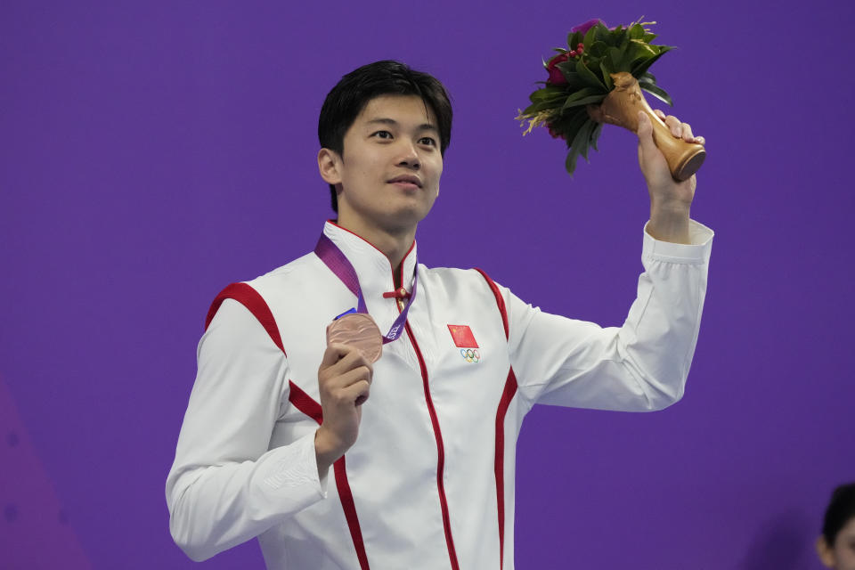 FILE - Bronze medalist Wang Shun celebrates on the podium during the victory ceremony for the men's 400m individual medley swimming at the 19th Asian Games in Hangzhou, China, on Sept. 26, 2023. (AP Photo/Lee Jin-man, File)