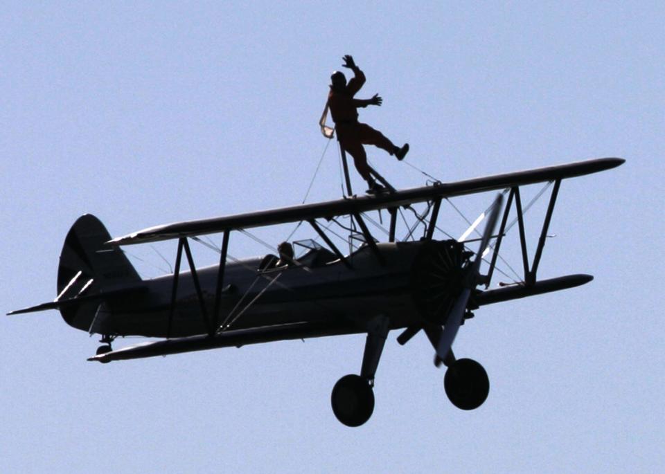 Chuck Tippett, a "wingwalker", waves from atop a 450 Stearman Aircraft while performing during the Flying Circus Air Show in Bealeton, Virginia October 28, 2007. Picture taken October 28, 2007. REUTERS/Stelios Varias