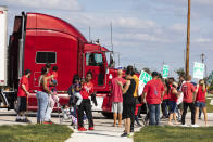 Picketing union members stand-off with a semi-truck attempting to enter the GM Davison Road Processing Center. United Automobile Workers remain on strike against GM on Tuesday, Sept. 17, 2019 in Burton, Mich. (Sara Faraj/The Flint Journal via AP)