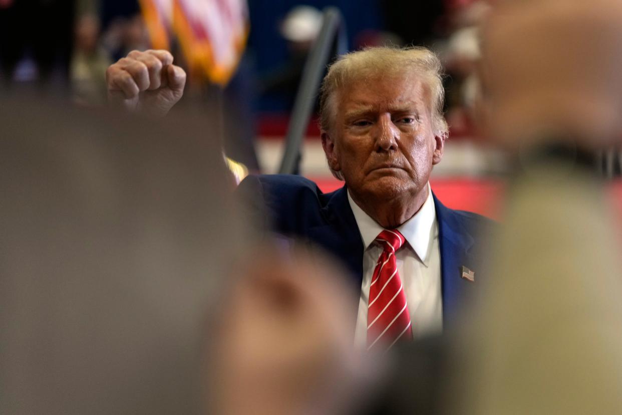 Republican presidential candidate former President Donald Trump gestures after speaking during a commit to caucus rally, Saturday, Jan. 6, 2024, in Clinton, Iowa. (AP Photo/Charlie Neibergall)