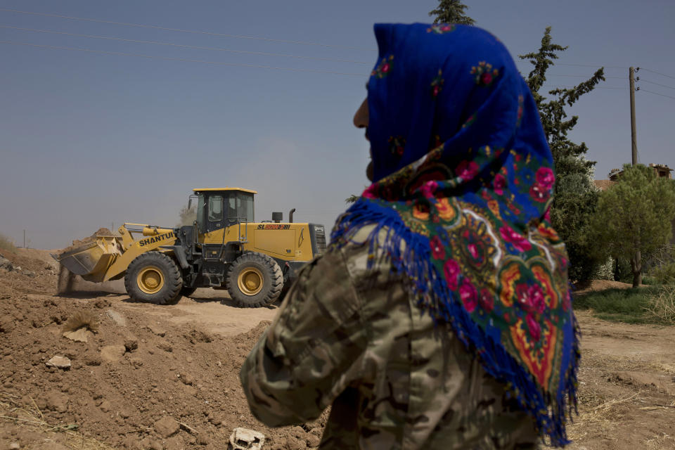 A soldier with the Tal Abyad Military Council, affiliated with the U.S.-backed Syrian Democratic Forces, oversees the collapse of a fortification in the safe zone between Syria and the Turkish border near Tal Abyad, Syria, on a joint patrol Friday, Sept. 6, 2019. Once part of the sprawling territories controlled by the Islamic State group, the villages are under threat of an attack from Turkey which considers their liberators, the U.S-backed Syrian Kurdish-led forces, terrorists.T o forestall violence between its two allies along the border it has helped clear of IS militants, Washington has upped its involvement in this part of Syria.. (AP Photo/Maya Alleruzzo)