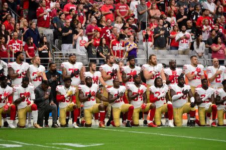 FILE PHOTO: Members of the San Francisco 49ers kneel during the National Anthem prior to a game against the Arizona Cardinals at University of Phoenix Stadium, Glendale, AZ, USA, Oct 1, 2017. Mandatory Credit: Matt Kartozian-USA TODAY Sports