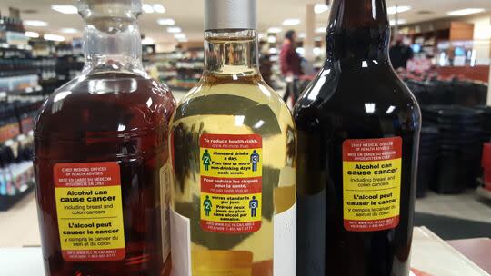 Cancer warning labels are seen on bottles involved in a labelling test program in Yukon. The program ended after industry groups raised concerns.