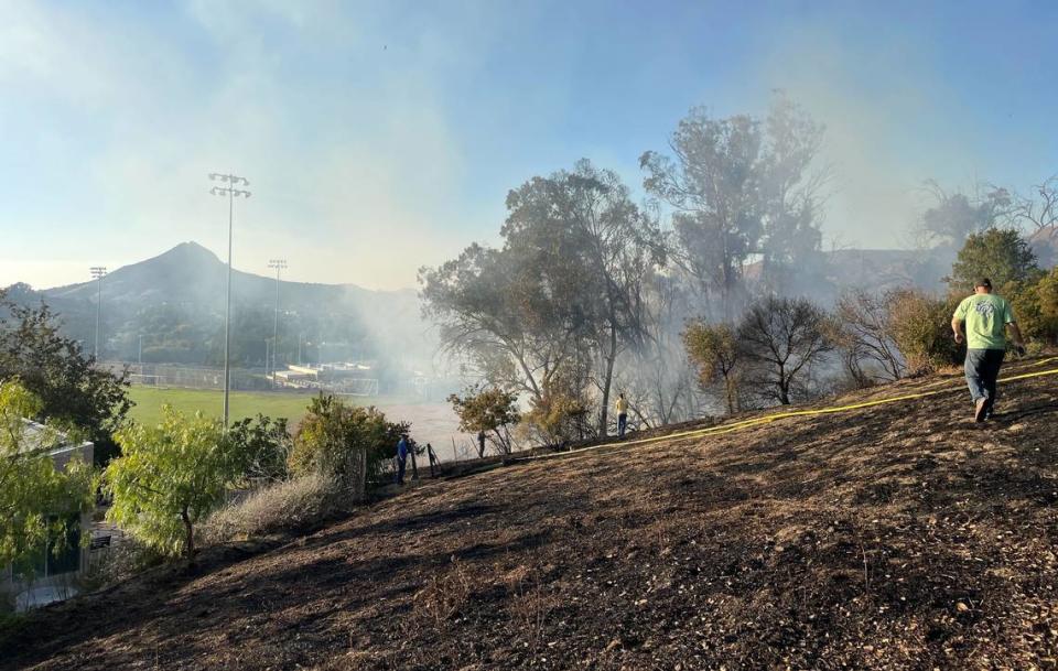 Smoke rises from a charred hill after a fire burned near San Luis Obispo High School on Monday, Oct. 30, 2023.