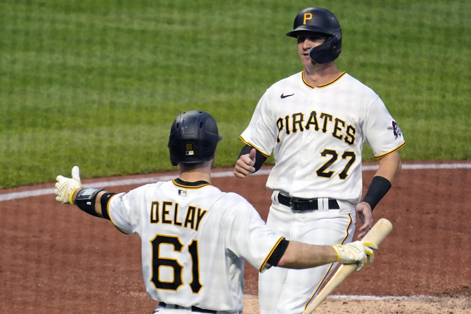 Pittsburgh Pirates' Kevin Newman (27) is greeted by Jason Delay after scoring on a sacrifice fly by Michael Chavis off New York Mets starting pitcher Taijuan Walker during the second inning of a baseball game in Pittsburgh, Tuesday, Sept. 6, 2022. (AP Photo/Gene J. Puskar)