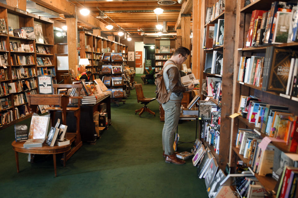 This photo taken on Dec. 7, 2012 shows Bryce Hoogland of Boise, Idaho browsing books at the downtown Tatered Cover book Store in Denver. You wouldn't know it from the marketing materials festooned with skiers and beer, but Denver is one of the most highly educated and literate cities in the country. That much is obvious inside Tattered Cover, a celebrated independent bookstore with two Denver locations (and one in the suburbs) that dwarf most superstores. (AP Photo/Ed Andrieski)