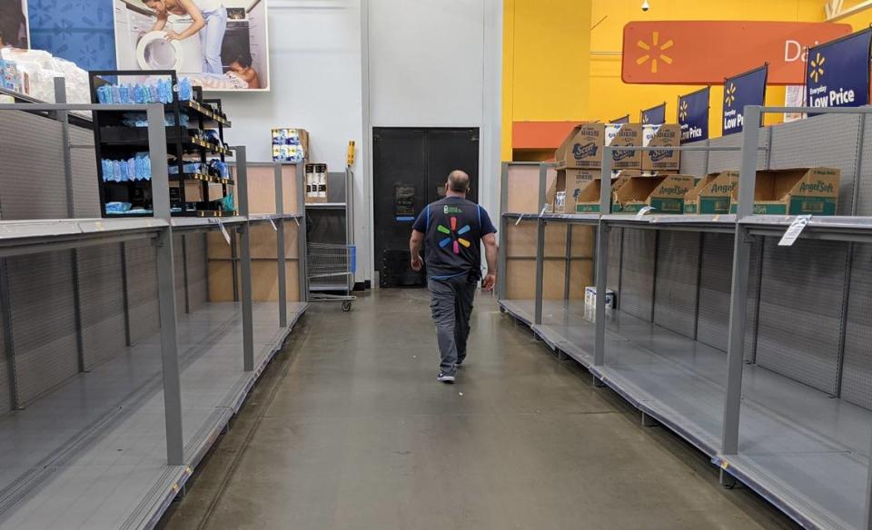 Shelves of toilet paper, shown, and paper towels had limited supply of products Friday at the Walmart in Lake Wylie. A sign asks customers to limit purchases to one per household.