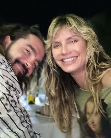 <p>heidiklum/Instagram</p> Heidi Klum smiles with husband Tom Kaulitz during dinner.