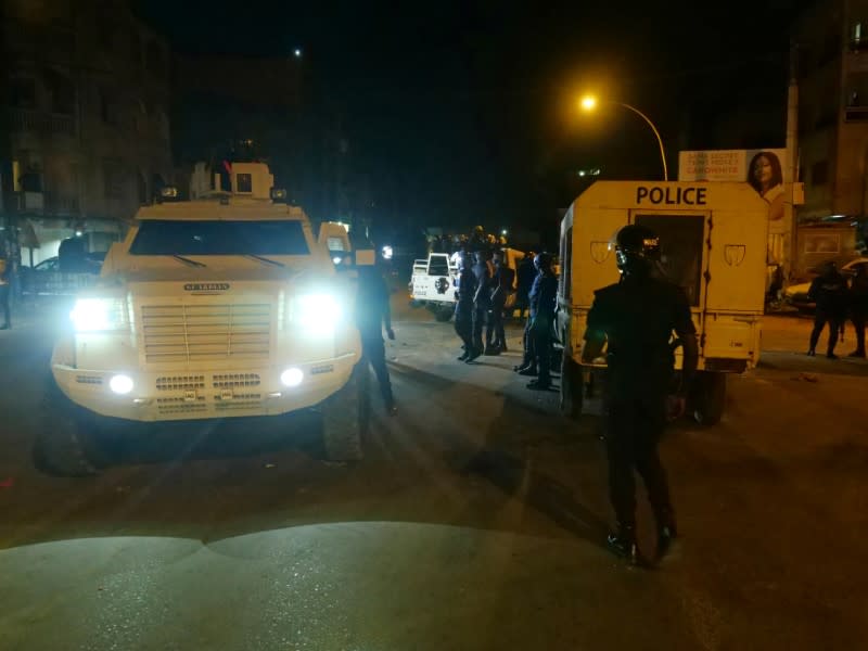 Police vehicles are parked at the scene during protests over a nationwide dusk-to-dawn curfew imposed because of the coronavirus disease (COVID-19) in Dakar