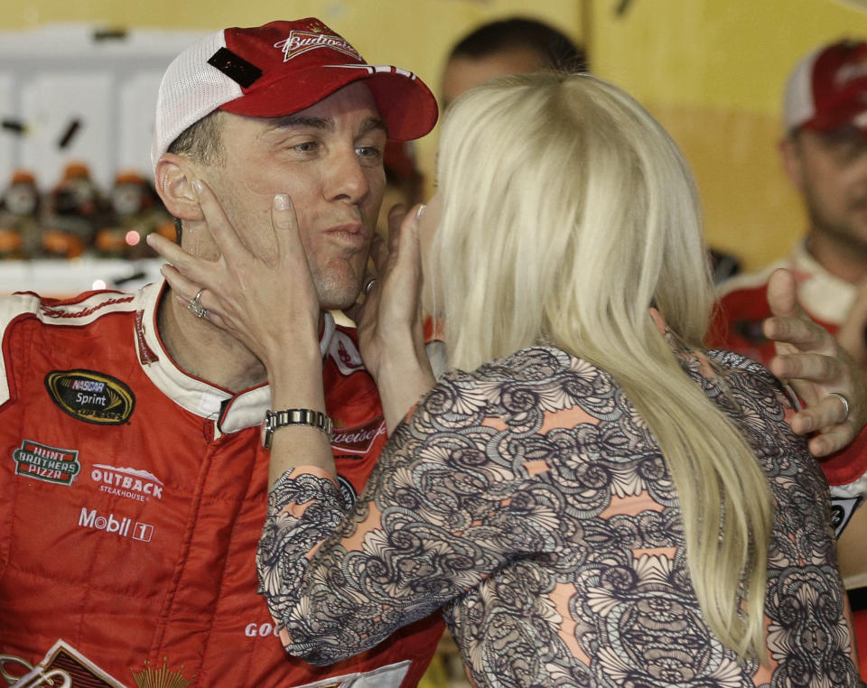 Kevin Harvick, left, gets a kiss from his wife, Delana Harvick, in Victory Lane after winning the NASCAR Sprint Cup series auto race at Darlington Raceway in Darlington, S.C., Saturday, April 12, 2014. (AP Photo/Chuck Burton)