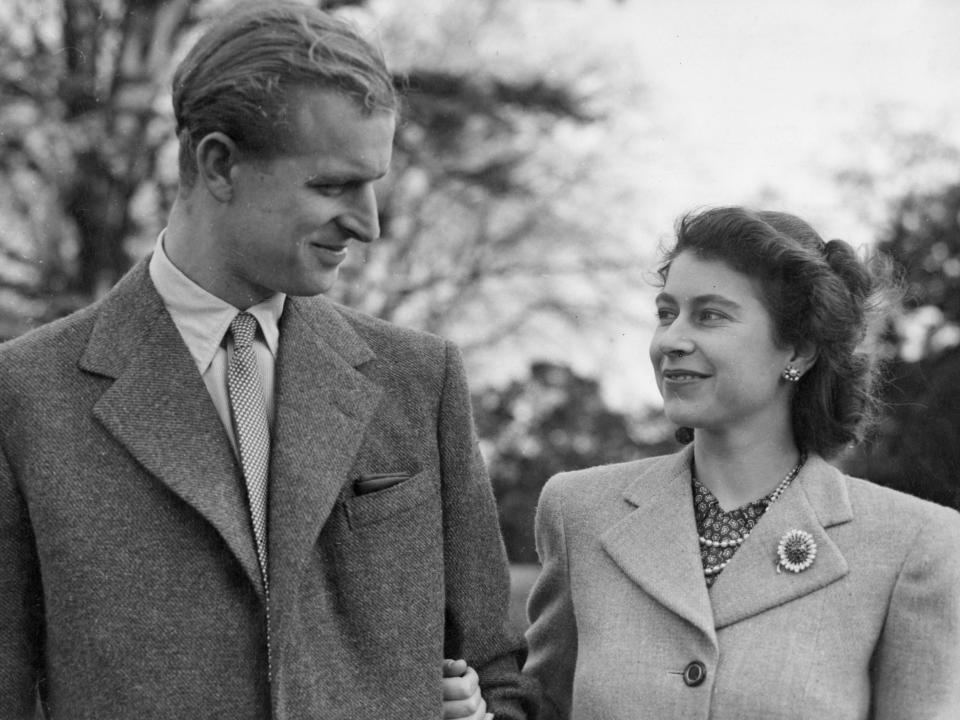 A young Prince Philip and Queen Elizabeth smile at each other in 1947.