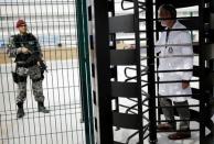 Francisco Radler, director of the Brazilian Laboratory for Doping Control, enters inside the Laboratory as a Brazilian army soldier patrols after an interview with Reuters in Rio de Janeiro, Brazil, July 29, 2016. REUTERS/Nacho Doce