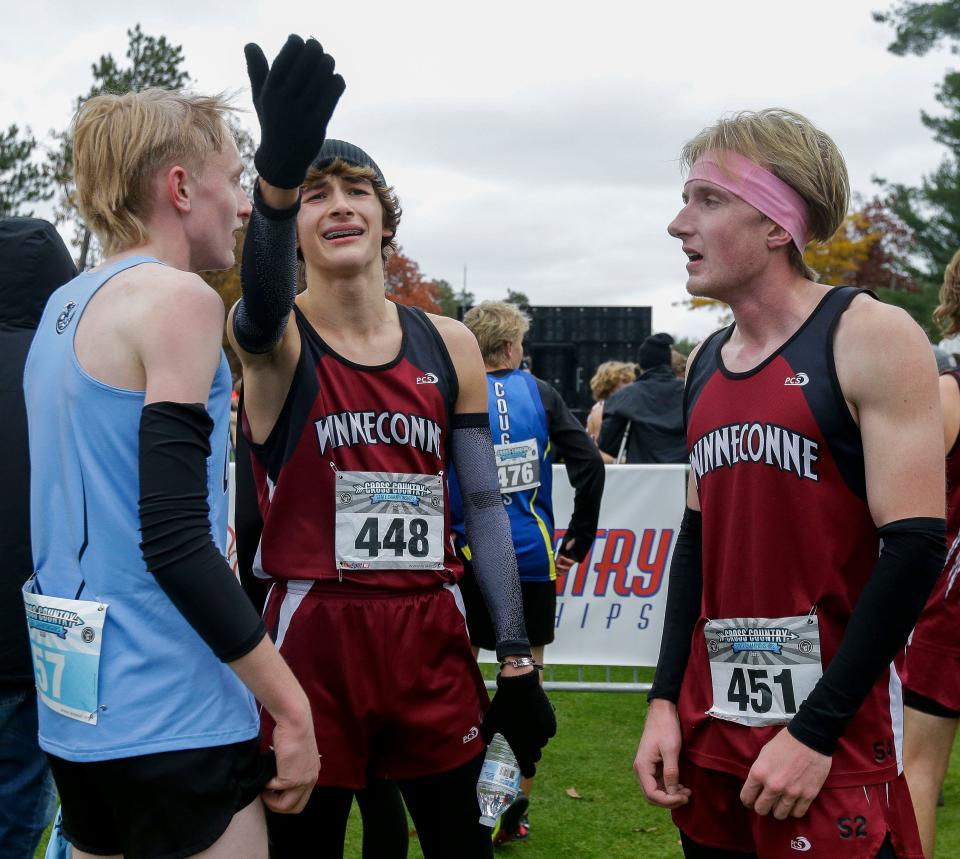 Winneconne's Grant Wenzelow (448) reacts to the team scores on the leaderboard during the WIAA Division 2 state boys cross-country meet Saturday in Wisconsin Rapids.