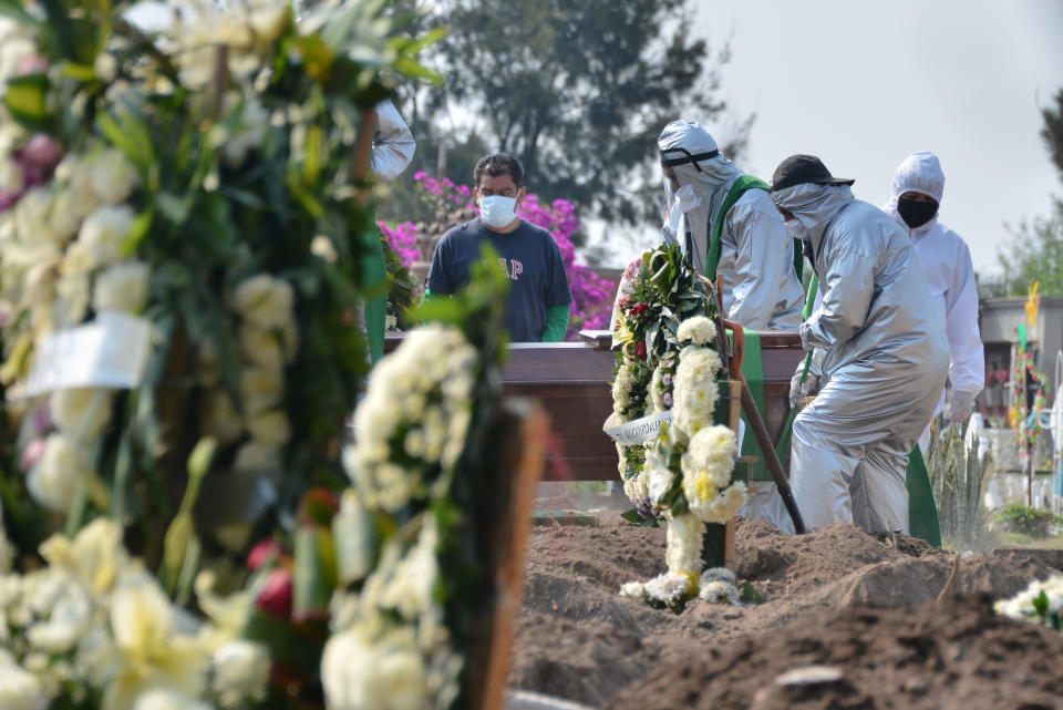 Funeral workers wear protective suit equipment while carrying a coffin of a person who died of Covid-19 to bury he in a grave located at special section intended for COVID-19 victims in a Mexican cemetery. Source: Barcroft Media via Getty Images