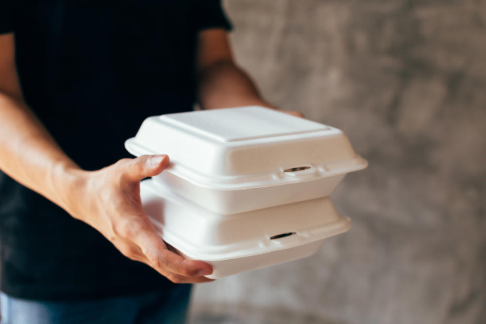 hands holding takeout containers