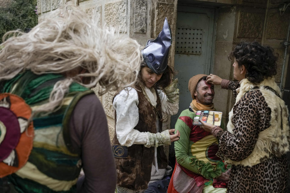 Performers apply make up ahead of the Purim parade in Jerusalem, Monday, March 25, 2024. For the first time after 42 years and amid the Israel-Hamas war, Jerusalem will hold the Purim on Monday. (AP Photo/Leo Correa)