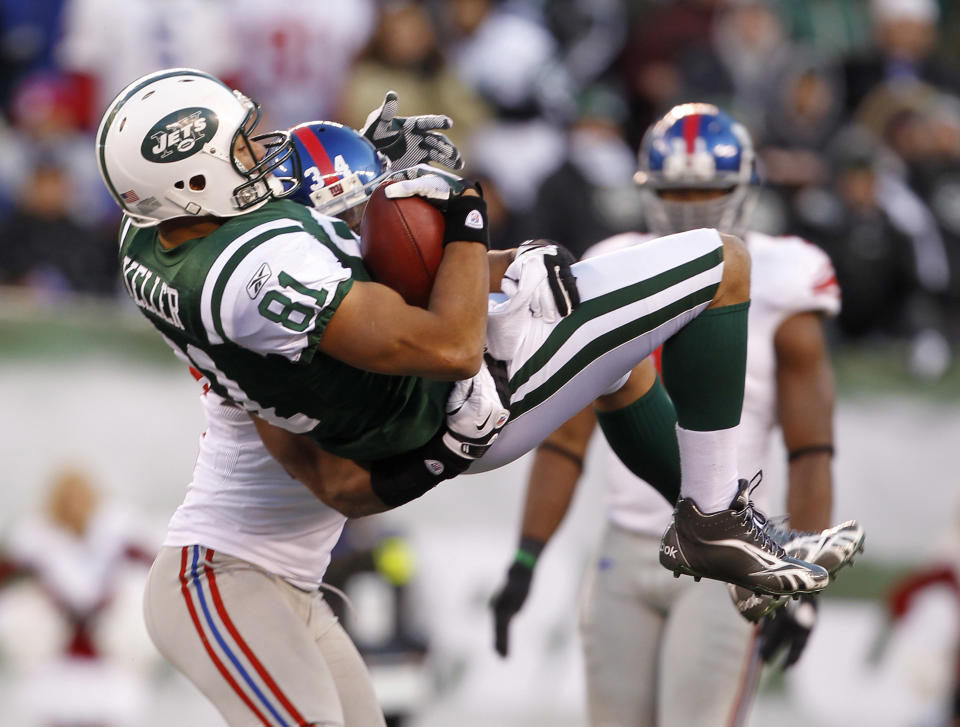 Dustin Keller #81 of the New York Jets makes a catch and is lifted and tackled by Deon Grant #34 of the New York Giants during the third quarter at MetLife Stadium on December 24, 2011 in East Rutherford. New Jersey. (Photo by Rich Schultz /Getty Images)