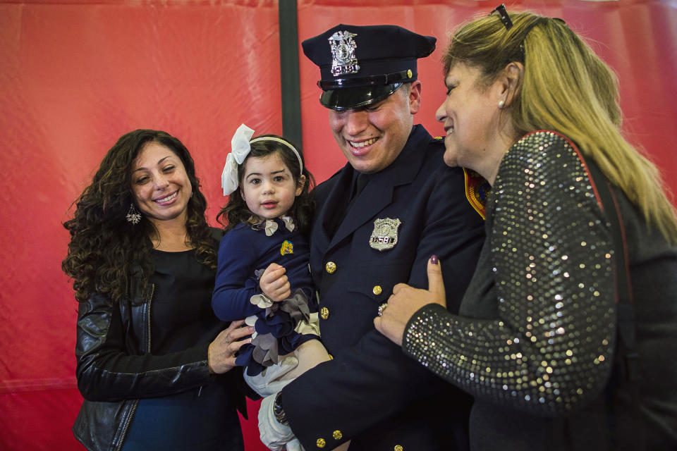 Matias Ferreira, center, celebrates with his 2-year-old daughter, his wife, left, and his mother during his graduation from the Suffolk County Police Department Academy at the Health, Sports and Education Center in Suffolk, Long Island, New York, Friday, March 24, 2017. Matias Ferreira, a former U.S. Marine Corps lance corporal who lost his legs below the knee when he stepped on a hidden explosive in Afghanistan in 2011, is joining a suburban New York police department. The 28-year-old graduated Friday from the Suffolk County Police Academy on Long Island following 29 weeks of training. (AP Photo/Andres Kudacki)