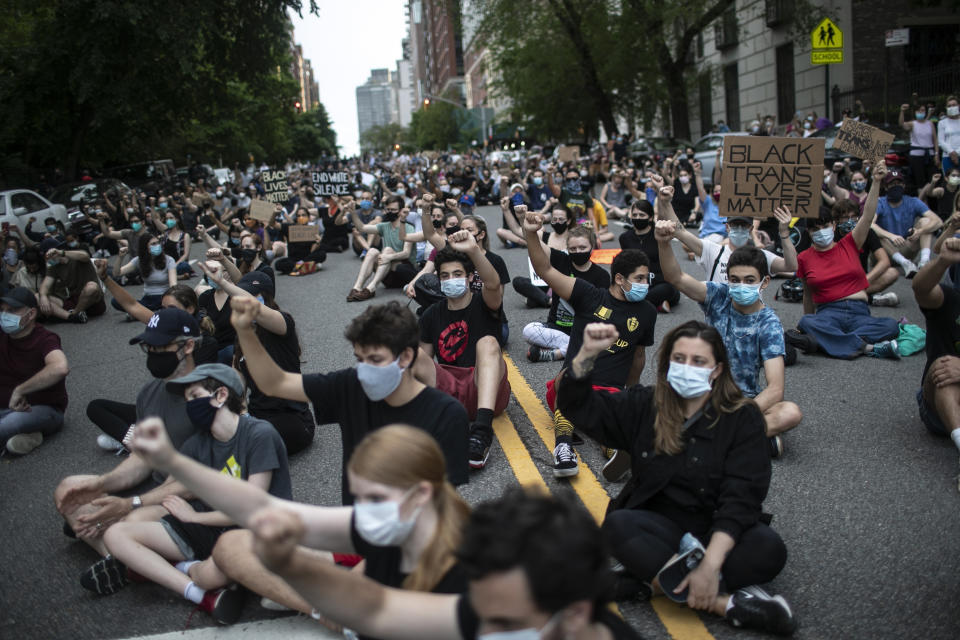 FILE- In this June 3, 2020 file photo, protesters in New York sit together with their fists in the air during a solidarity rally calling for justice over the death of George Floyd. Concerned about people packed in tightly during the recent protests, New York Gov. Andrew Cuomo says the thousands of people protesting the death of George Floyd have a "civic duty" to be tested for the coronavirus. (AP Photo/Wong Maye-E)