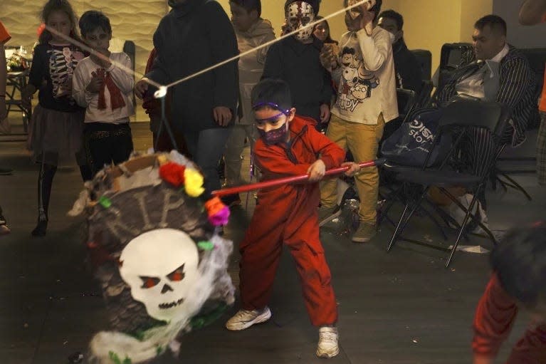 A child strikes a piñata during a Day of the Dead celebration in Mexico City, Oct. 31, 2021. The U.S. Postal Service on Friday, Sept. 8, 2023 rolled out its latest special edition postage stamps, paying homage to Piñatas.