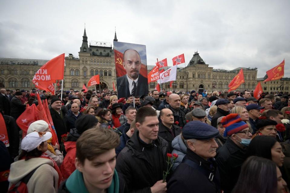 Russian Communist Party members and supporters carry portraits of Vladimir Lenin as they walk towards the Mausoleum of the Soviet Union founder and revolutionary leader Vladimir Lenin marking the 152th anniversary of his birth, on Red Square in Moscow, April 22, 2022. (Photo by Natalia Kolesnikova /AFP via Getty Images)