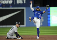 Toronto Blue Jays shortstop Bo Bichette, right, forces out New York Yankees' Aaron Judge, left, at second base then turns the double play to get out Yankees' Anthony Rizzo at first base during third-inning baseball game action in Toronto, Monday, Sept. 26, 2022. (Nathan Denette/The Canadian Press via AP)