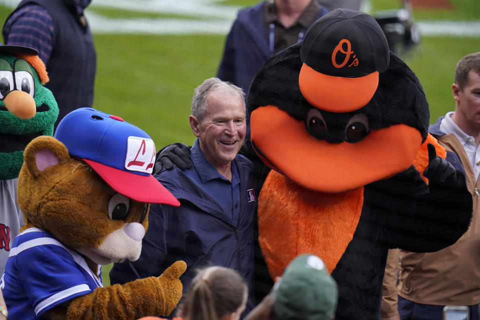 Former President George W. Bush, center, is surrounded by mascots during pre-game festivities before the MLB Little League Classic baseball game between the Baltimore Orioles and the Boston Red Sox in Williamsport, Pa., Sunday, Aug. 21, 2022. (AP Photo/Gene J. Puskar)