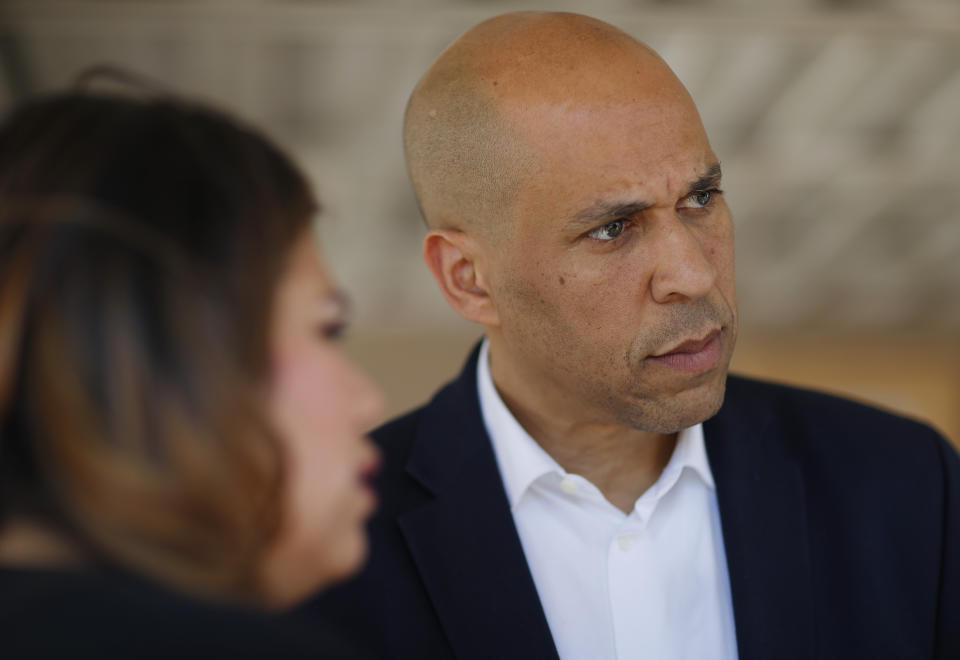 Democratic presidential candidate Sen. Cory Booker, right, speaks with Astrid Silva, left, and others after a round table with Dreamers and immigrant activists, Saturday, April 20, 2019, in Las Vegas. (AP Photo/John Locher)