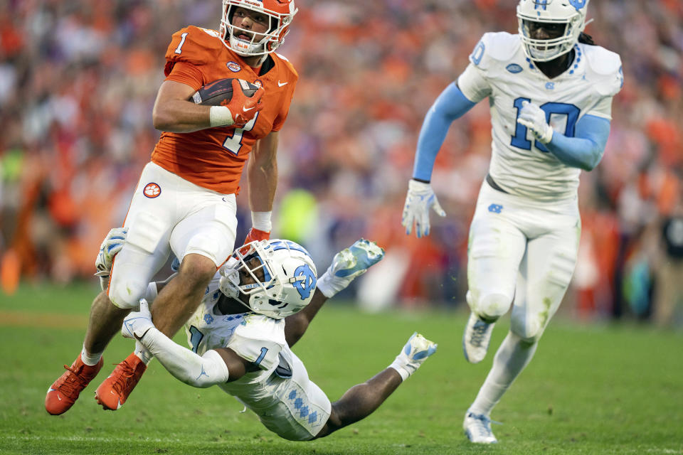 North Carolina defensive back Antavious Lane, bottom left, tries to tackle Clemson running back Will Shipley, top left, during the first half of an NCAA college football game Saturday, Nov. 18, 2023, in Clemson, S.C. (AP Photo/Jacob Kupferman)