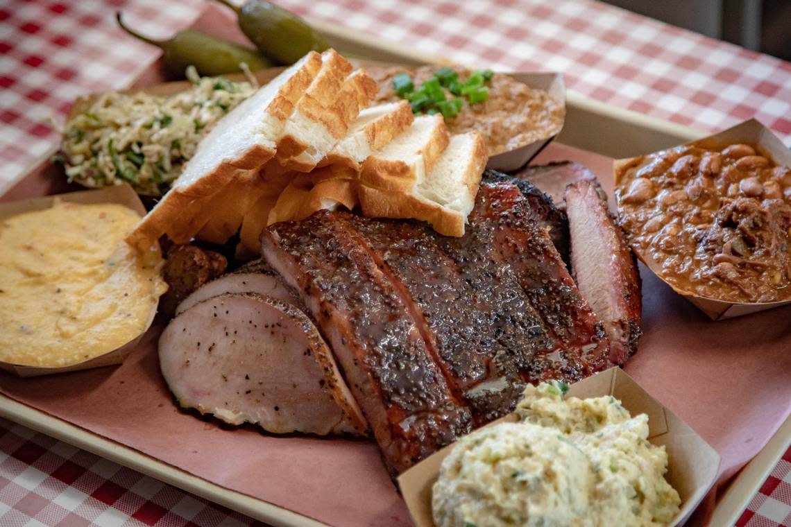 Ribs, smoked turkey, sausage, potato salad, grits and more is piled on a tray at Goldee’s Barbecue in Fort Worth on Saturday, April 22, 2023.