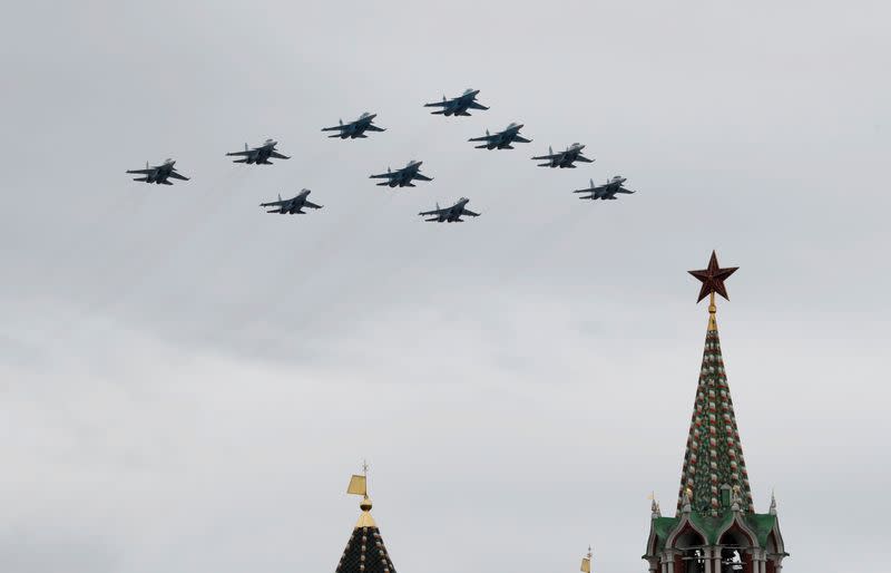 Su-30SM, Su-34 and Su-35S combat aircraft fly in formation during an air parade on Victory Day in central Moscow