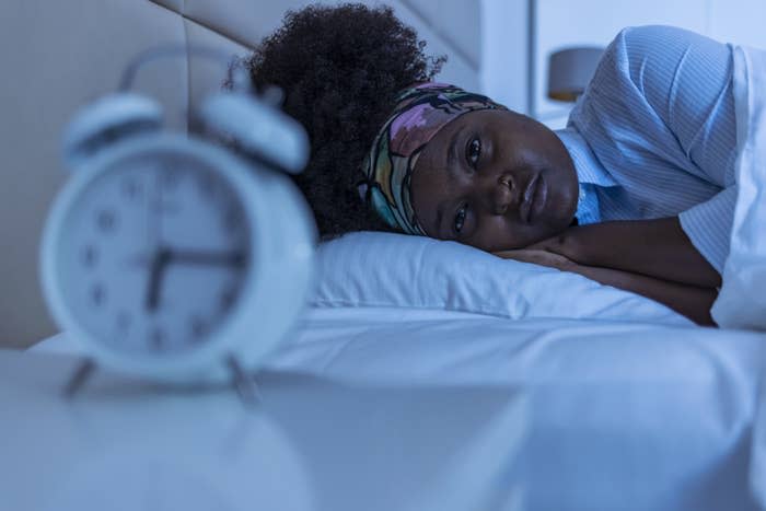 A woman lying in bed trying to sleep