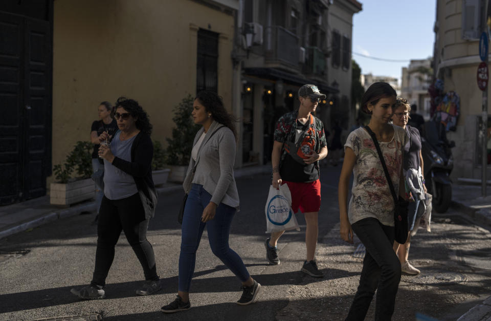 Tourists walks in Plaka district of Athens , on Friday, Oct. 7, 2022. As Europe tilts toward recession, with economies weighed down by high energy prices and other effects of the war in Ukraine, a strong rebound in tourism by southern European Union members has eased the continental slowdown.(AP Photo/Petros Giannakouris)