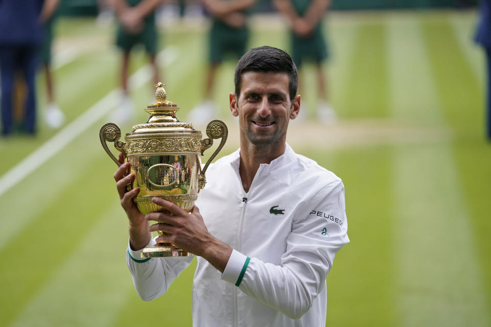 FILE - In this July 11, 2021, file photo, Serbia's Novak Djokovic holds the trophy after his win over Italy's Matteo Berrettini in the men's singles final match of the Wimbledon Tennis Championships in London. Djokovic is 26-0 in Grand Slam matches in 2021, moving him two victories away from being the first man to win all four major tennis championships in one season since Rod Laver in 1969. (AP Photo/Alberto Pezzali, Pool)