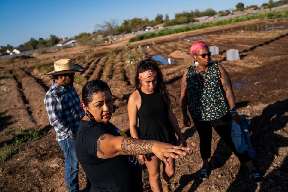Chef Maria Parra Cano, center left, points out areas that need attention to Brian Cano, left, Alexis Ruby Trevizo, center, and Nelli Evans, right, at Food Forest Cooperative on March 17, 2022, in Phoenix. The farm co-op is a 1.5-acre plot of land located on Spaces of Opportunity in south Phoenix.