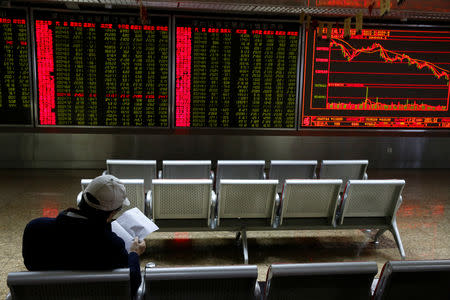 An investor sits in front of displays showing stock information at a brokerage office in Beijing, China October 11, 2018. REUTERS/Thomas Peter/Files