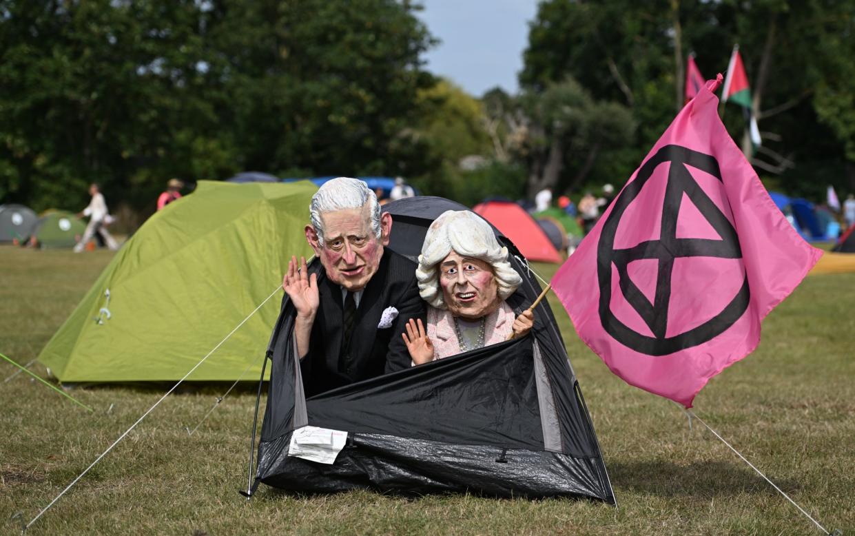 Activists in masks of the King and the Queen in a tent on Windsor Home Park