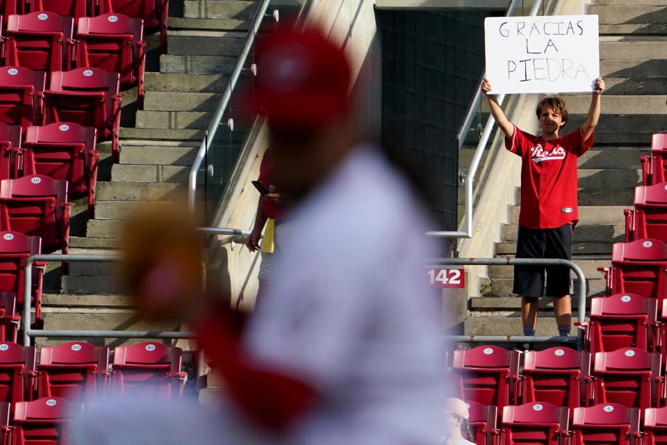A fan holds a sign thanking Cincinnati Reds starting pitcher Luis Castillo (58), foreground, as he warms up before the first inning of a baseball game against the Miami Marlins, Wednesday, July 27, 2022, at Great American Ball Park in Cincinnati. Castillo is expected to be traded by the trade deadline Aug. 2.